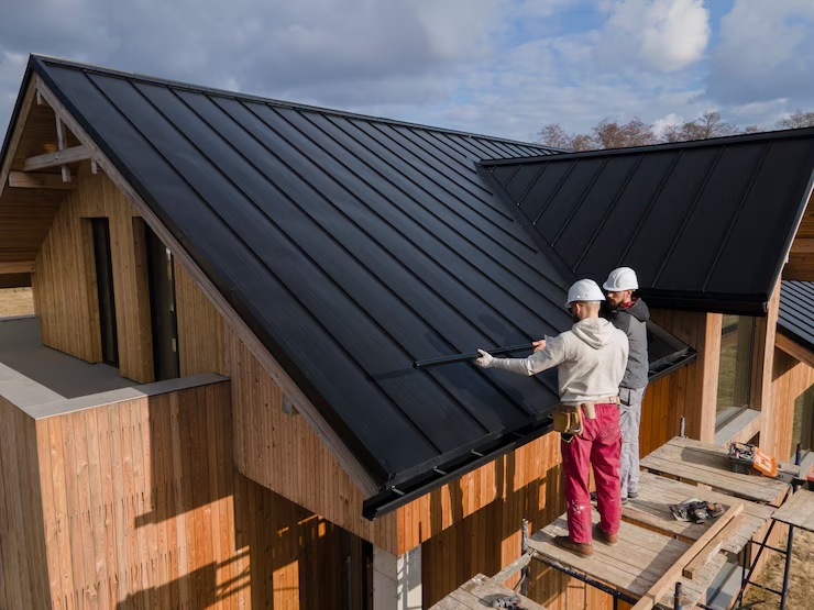 Experienced roof installers installing a roof at a residential building. To get a free estimate, get in touch with us today.