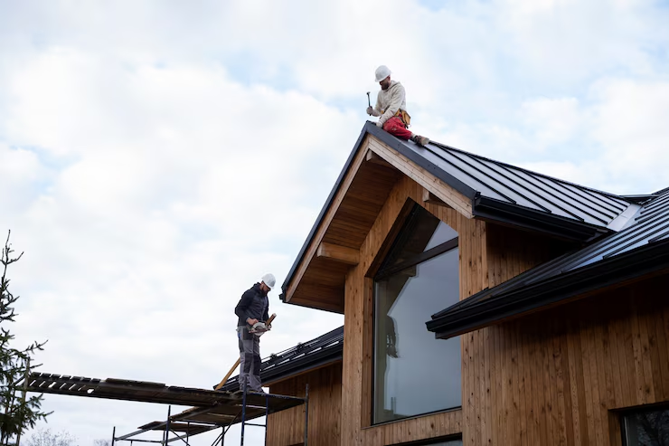 Roof professionals installing a roof on a residential building. To get an estimate, get in touch today.