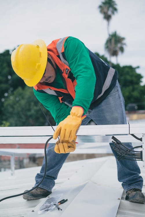 A man precisely working on the repair of a rooftop. Reach out to us today and get your free estimate.