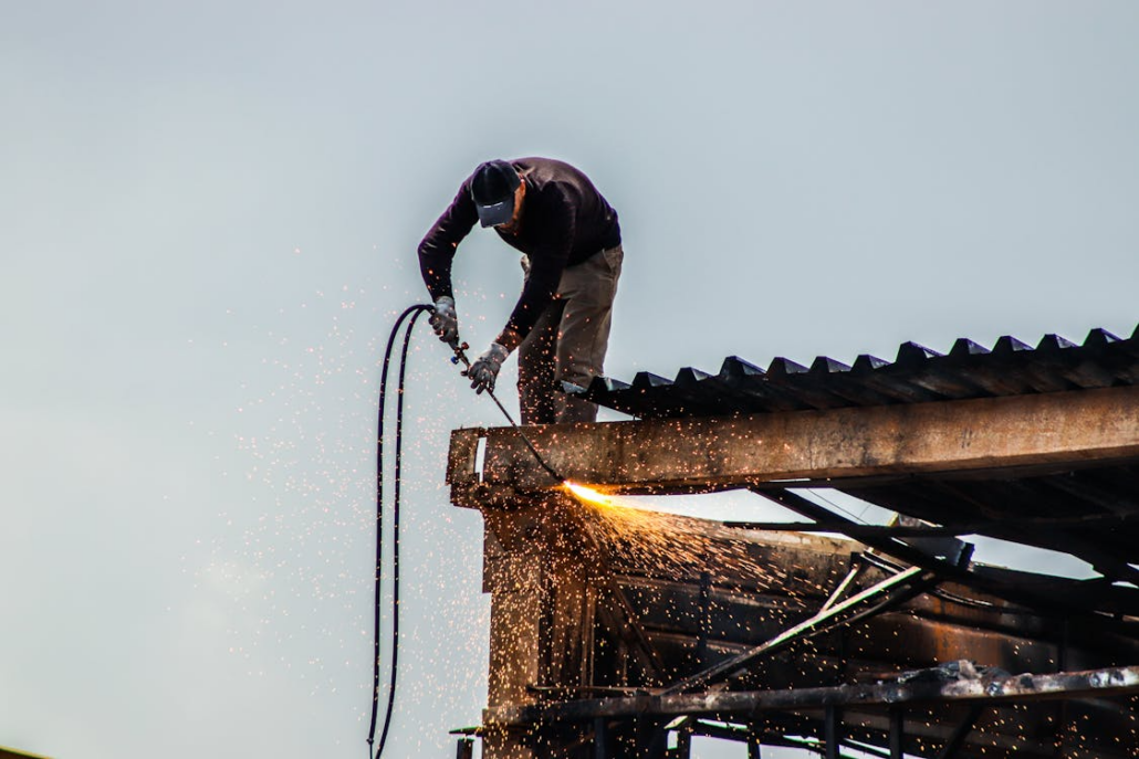 A licensed roofing expert working on the installation of a roof. Reach out to us today to receive your free estimate.