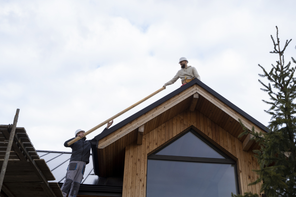 Experienced roofers working on the installation of a wooden rooftop. Get your free estimate today by contacting us.