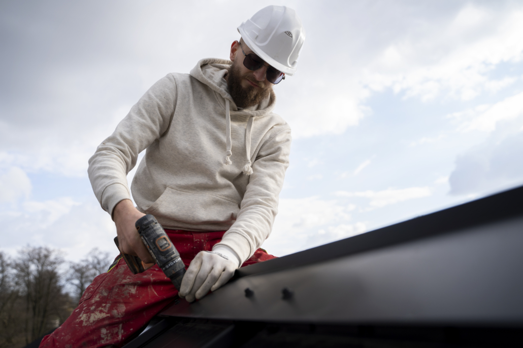A licensed roofing contractor working on the installation of a roof. Get in touch with us today and receive your free estimate.