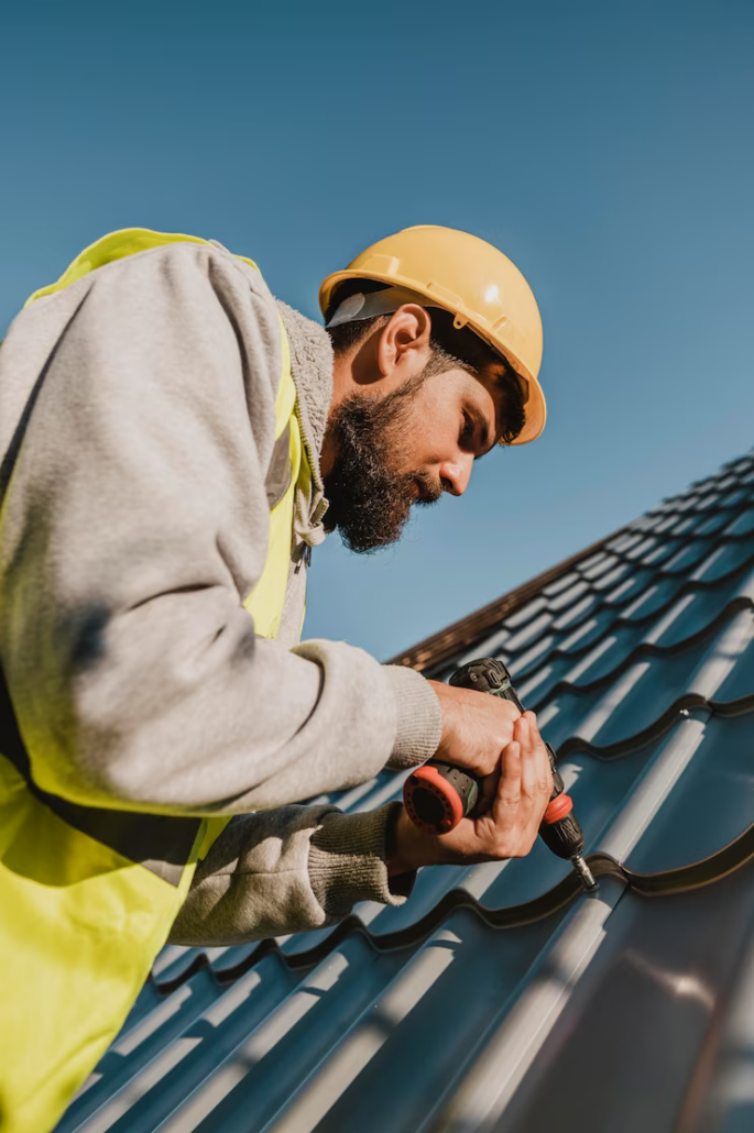 An expert roofer drilling while working on the installation of a roof. Get an estimate today by getting in touch with us.