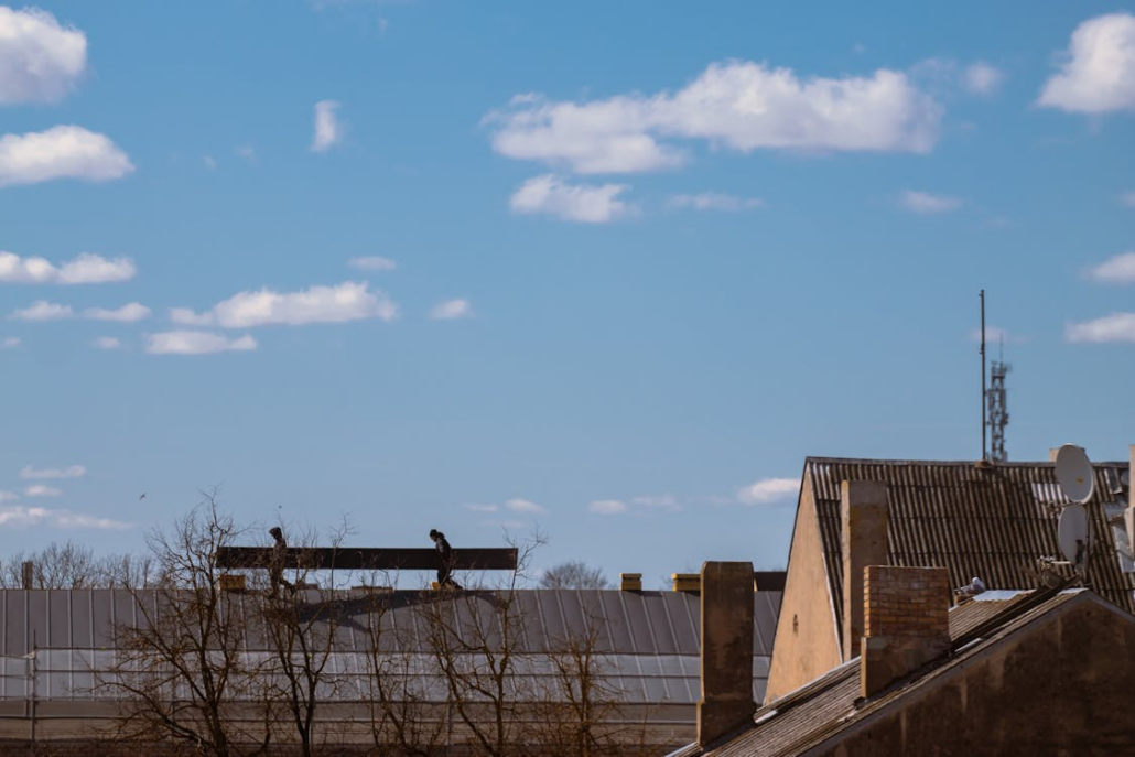 Experienced roofers working on the construction of a roof. Reach out to us today to get your free estimate.