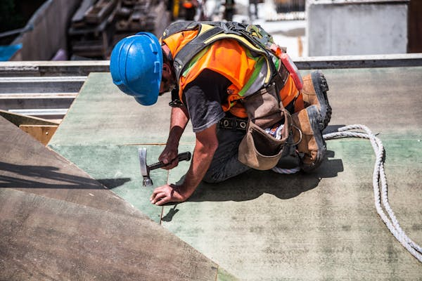 A professional roofer repairing a roof with dedication and care. To get an estimate, get in touch with us today.
